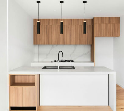 Small kitchen renovation with wooden cabinetry and white benchtops